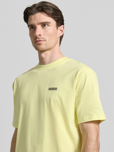 Männermodel trägt Herren T-Shirt mit Label-Print Modell 'Baine' von WOODBIRD in Hellgelb, Reine Baumwolle, Regular-Fit, Nahaufnahme Oberkörper.