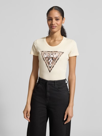 Vrouwenmodel draagt Slim Fit T-shirt met Ziersteinbesatz van Guess, katoenmix, logodetail, ronde hals, ruglengte maat S 62 cm, voorkant bovenlichaam- close-up