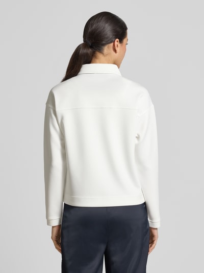 Frauenmodel trägt Jacke mit Umlegekragen und Brusttaschen von monari in Weiß, gerader Schnitt, feine Textur, Ganzkörperansicht Rückansicht.