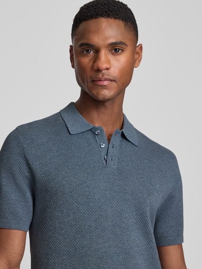 Męskimodel nosi koszulkę polo Slim Fit Poloshirt model 'Triton' od Drykorn, z bawełny, kołnierzyk polo, krótki rękaw, fakturowany wzór, zbliżenie na górę ciała.