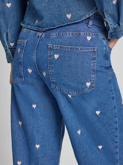 Frauenmodel trägt Loose Fit Wide Leg Jeans aus reiner Baumwolle Modell 'VEGA' von Only mit Motiv-Stitching, Denim-Optik, 5-Pocket-Design, Nahaufnahme Rückansicht.