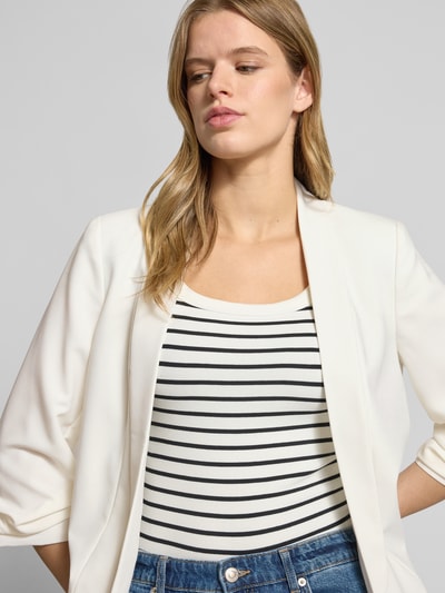 Kobiece model prezentuje Regular Fit Longblazer mit Viskose-Anteil Model 'BOSELLA' od Pieces, efekt: jednolity kolor, kołnierz z połami, rękaw o dł. 3/4, poduszki na ramionach, wykończenie materiału: tkana faktura, półzbliżenie górnej części ciała.