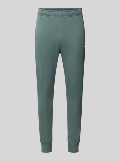 Produktfoto, Straight Fit Sweatpants aus Baumwoll-Mix mit Logo-Patch von Champion in Grün, elastischer Bund, gerippte Beinabschlüsse, Eingrifftaschen, schlichte Struktur, Herrenkontext