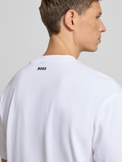 Männermodel trägt Regular Fit T-Shirt aus Baumwoll-Mix Modell 'TEETIM' von BOSS Orange, Optik: Unifarben, Label-Print, Nahaufnahme Rückansicht.