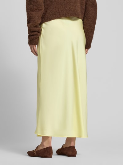 Frauenmodel trägt Maxirock aus Satin Modell 'VIELLETTE' von Vila in Gelb, gerader Schnitt, High Waist, Rückansicht, Ganzkörperansicht.