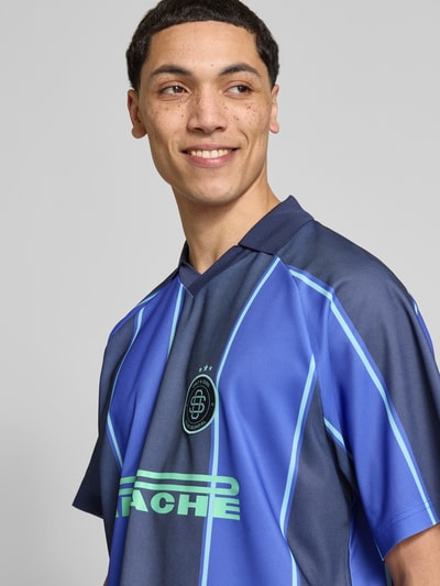 Männermodel trägt Herren Poloshirt von Only & Sons, Modell 'ZIDAN', Optik: Unifarben, Gestreift, Loose-Fit, Motiv-Print, Label-Stitching, Polokragen, V-Ausschnitt, Ärmelform: Kurzarm, Materialverarbeitung: Piqué, Farben in Blau und Schwarz, Nahaufnahme Oberkörper.