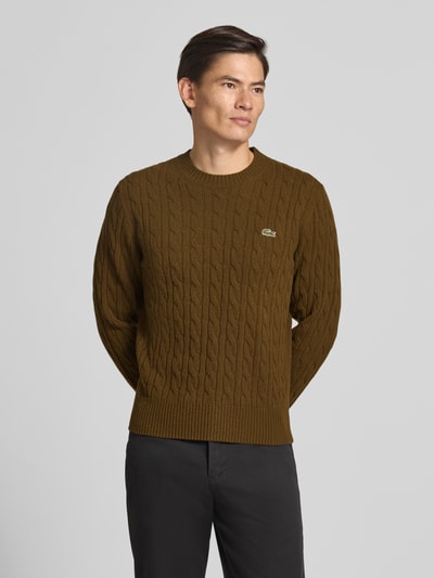 Männermodel trägt Regular Fit Pullover aus reiner Wolle von Lacoste in Braun mit Strukturmuster, Nahaufnahme Oberkörper, Herren Pullover von Lacoste.