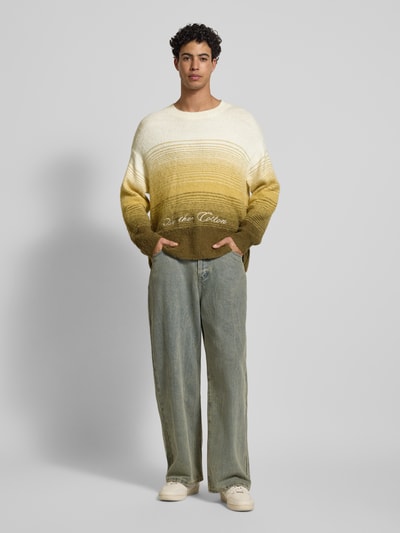 Männermodel trägt Oversized Strickpullover mit gerippten Abschlüssen von ANOTHER COTTON LAB, mehrfarbig, Material-Mix, Ganzkörperansicht von vorne.