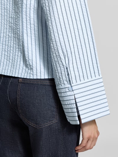 Frauenmodel trägt Relaxed Fit Hemdblusen mit Viskose-Anteil von Neo Noir, hellblau gestreift, Baumwoll-Mix, taillierte Passform, Nahaufnahme Oberkörper.
