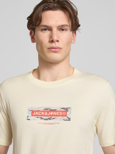 Männermodel trägt T-Shirt mit Logo und Rundhalsausschnitt von Jack & Jones in Beige, reine Baumwolle, Regular Fit, Nahaufnahme Oberkörper.