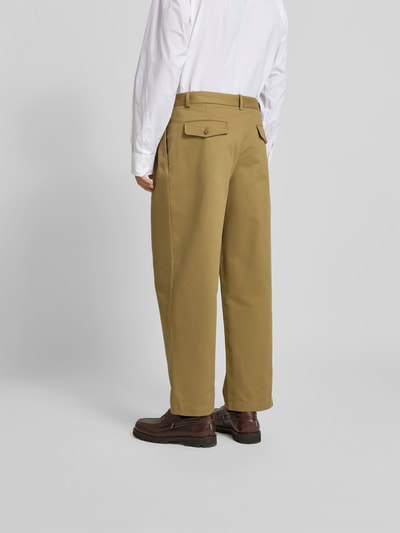 Männermodel trägt Relaxed Fit Stoffhose aus Baumwolle von MAISON KITSUNÉ in Beige mit Gesäßtasche, Ganzkörperansicht Rückansicht. Kontext: Herren Stoffhose, Reine Baumwolle, Relaxed Fit, Eingriff- und Gesäßtaschen, Knopf- und Reißverschluss, Zierfalten, Innenbeinlänge bei Größe 42: 72 cm, Bundweite bei Größe 42: 43 cm.