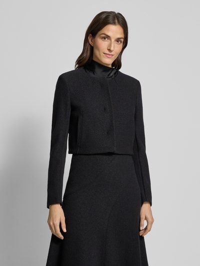 Modelka kobieca nosi Boxy Fit Kurzblazer aus reiner Schurwolle Modell 'JICENA' od BOSS, czarny, gładki, długi rękaw, widok całej sylwetki z przodu.