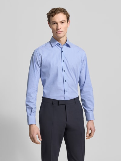 Męski model nosi Regular Fit Businesshemd mit Streifenmuster von ETERNA z bawełny, kołnierzyk typu new kent, długie rękawy, wzór w paski, listwa guzikowa, sportowe mankiety, nie wymaga prasowania, długość tyłu 79 cm, szerokość ramion 46 cm, długość rękawów 65 cm, całkowity widok z przodu.