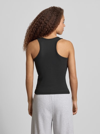 Frauenmodel trägt Slim Fit Tank Top aus Baumwoll-Mix Modell 'RUKA BOXER' von Pieces, unifarben, Rippstruktur, Ganzkörperansicht Rückansicht.