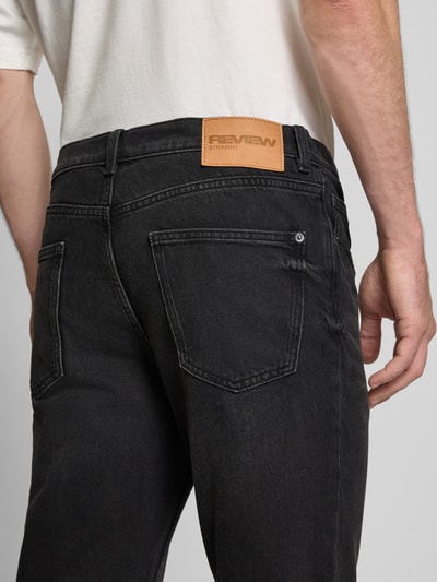 Männermodel trägt Straight Fit Jeans im Five-Pocket-Design von REVIEW, schwarze Waschung, Baumwoll-Elasthan-Mix, Detailaufnahme Rückansicht.