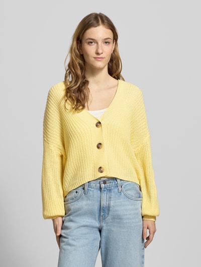 Frauenmodel trägt Regular Fit Strickjacke mit einreihiger Knopfleiste Modell 'CAROL NICE' von Only, unifarben, Strickoptik, Ganzkörperansicht von vorne.