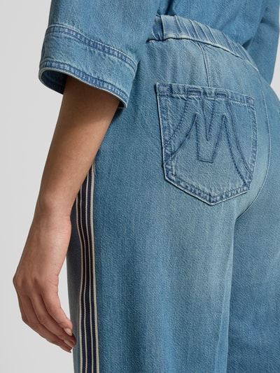 Frauenmodel trägt Wide Fit Jeans mit Lyocell-Anteil von Marc Cain, blaue Denim-Struktur, Gesäßtasche, Detailaufnahme Rückansicht, Baumwoll-Lyocell-Anteil, Tunnelzug, Eingriffstaschen, Bügelfalten, Bundweite 38 cm, Innenbeinlänge 83 cm, Größe 36.