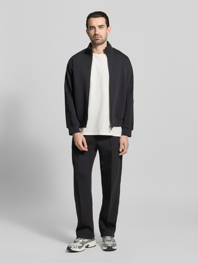 Männermodel trägt Sweatjacke mit Stehkragen und Zweiwege-Reißverschluss von Emporio Armani, Baumwoll-Mix mit Stretch-Anteil, Regular-Fit, Schwarz, Eingrifftaschen, Ganzkörperansicht von vorne.