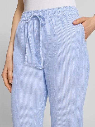 Frauenmodel trägt Stoffhose mit Streifenmuster und elastischem Bund von Neo Noir, Reine Baumwolle, Relaxed-Fit, Tunnelzug, Nahaufnahme Oberkörper.