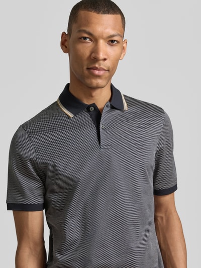 Männermodel trägt Regular Fit Poloshirt mit Polokragen und kurzer Knopfleiste von bugatti in Reine Baumwolle, Label-Detail, Nahaufnahme Oberkörper. Rückenlänge bei Größe M: 70 cm.