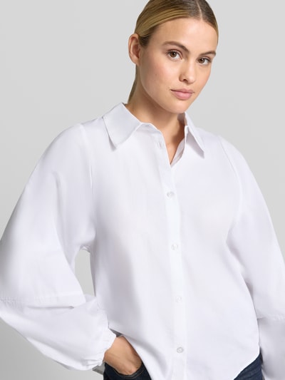 Frauenmodel trägt Regular Fit Hemdbluse mit Ballonärmeln Modell 'Sunna' von My Essential Wardrobe, weiß, Knopfleiste, Hemdblusenkragen, Nahaufnahme Oberkörper.