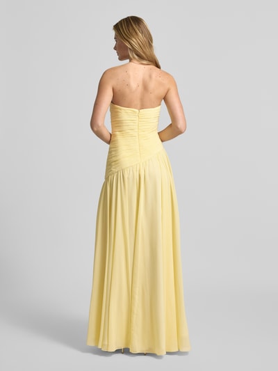 Frauenmodel trägt Slim Fit Abendkleid in Falten-Optik von Luxuar, gelber Stoff, schulterfrei, blickdichter Unterrock, Ganzkörperansicht Rückansicht.