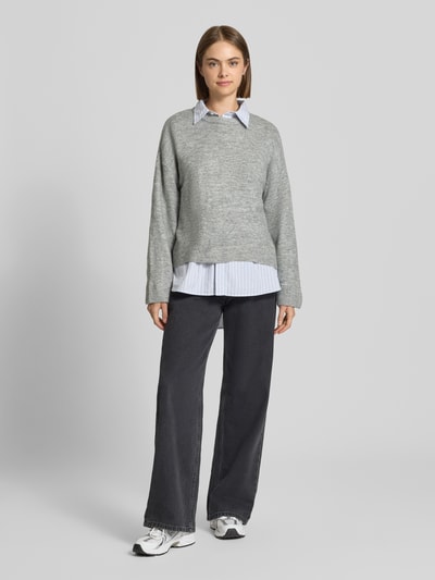 Modelka nosi sweter z okrągłym dekoltem Relaxed Fit Pullover mit Rundhalsausschnitt model 'SIMONI' od ONLY, szary melanż, damski, pełny widok z przodu.