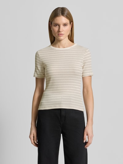 Kobieta nosi damski t-shirt z mieszanki bawełny z dodatkiem streczu, krój slim fit, model 'Soleili' od OPUS, okrągły dekolt, długość tyłu w rozmiarze 36: 55 cm, jasny kolor, faktura prążkowana, prosty fason, widok całej sylwetki z przodu.