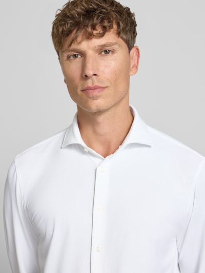 Männermodel trägt Slim Fit Business-Hemd mit Haifischkragen von Jake*s, Weiß, Strukturmuster, Material-Mix mit Stretch-Anteil, Nahaufnahme Oberkörper. Rückenlänge bei Größe 39/40: 78 cm, Schulterbreite: 48 cm, Ärmellänge: 68 cm.