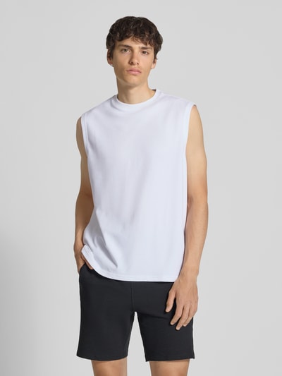 Männermodel trägt Herren T-Shirt Regular Fit Shirt aus Baumwoll-Mix Modell 'CASPIAN AIRFLEX BOXY' von Only & Sons, Optik: Unifarben, Rundhals, Ärmelform: Ohne, Materialverarbeitung: Jersey, Farbe: Weiß, Textur: Glatt, Ganzkörperansicht von vorne.