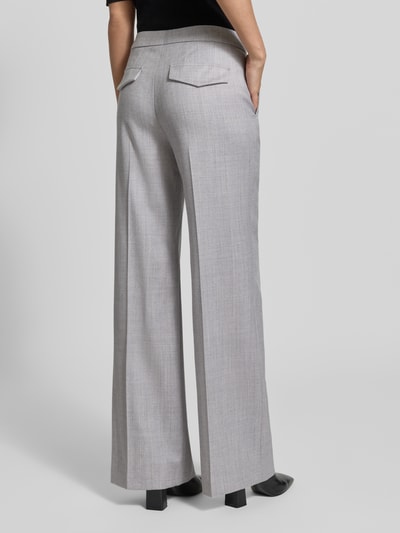 Frauenmodel trägt Stoffhose aus Schurwolle-Mix mit Bügelfalte von windsor., hellgrau, Wide Fit, angedeutete Gesäßleistentaschen, Ganzkörperansicht Rückansicht.