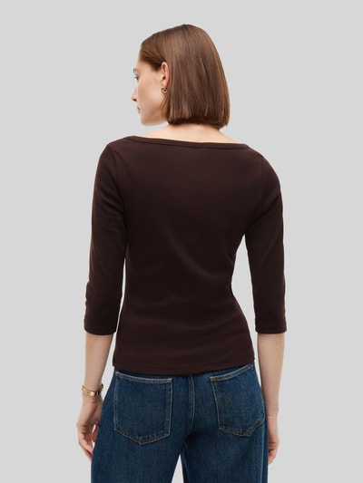 Frauenmodel trägt Slim Fit Langarmshirt aus reiner Baumwolle von Tommy Hilfiger in Dunkelbraun, kombiniert mit blauen Jeans, Ganzkörperansicht Rückansicht, Damen T-Shirt von Tommy Hilfiger.