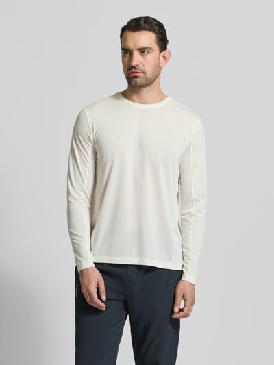 Männermodel trägt Funktionsshirt mit Logo und Rundhalsausschnitt von Salomon in Creme, Regular Fit, Langarm, glatte Textur, Ganzkörperansicht von vorne.