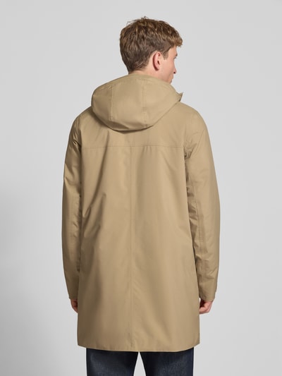 Männermodel trägt Regular Fit Mantel mit Kapuze Modell 'Brussel' von Helly Hansen in Beige, glatte Textur, Ganzkörperansicht Rückansicht. Rückenlänge 96 cm, Schulterbreite 46 cm, Brustweite 51 cm, Ärmellänge 66 cm.