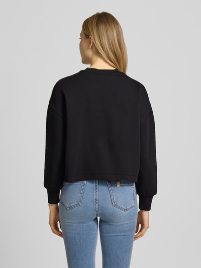 Frauenmodel trägt Sweatshirt mit Logo-Print und Rundhalsausschnitt von ARMANI EXCHANGE, mieszanka bawełny z dodatkiem streczu, krój loose fit, okrągły dekolt, nadruk z logo. Ganzkörperansicht Rückansicht.