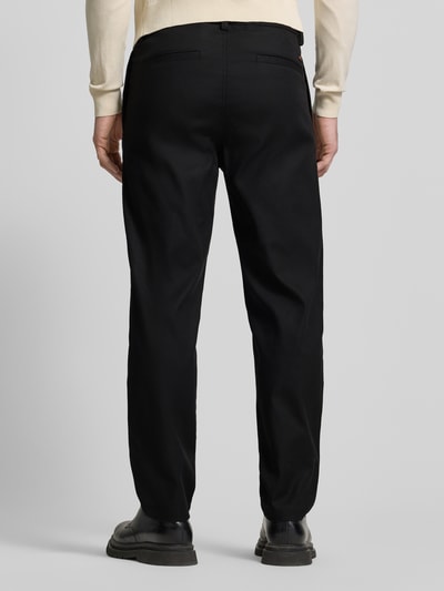 Męski model nosi Tapered Chino mit Kordelzug Model 'CHINO ST-P' od BOSS Orange, jednokolorowe, bawełniany mix, krój tapered, aplikacja z metką, szlufki na pasek, trok, zamek na guzik, tunel; całkowity widok z tyłu
