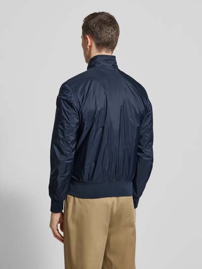 Mężczyzna nosi granatową Jacke mit Reißverschlusstaschen Modell 'Brahms' von Blauer Usa, krój regular fit, widok całego ciała z tyłu. Szerokość w rozmiarze M: 57 cm, długość tyłu: 65 cm, szerokość ramion: 46 cm, długość rękawa: 66 cm.