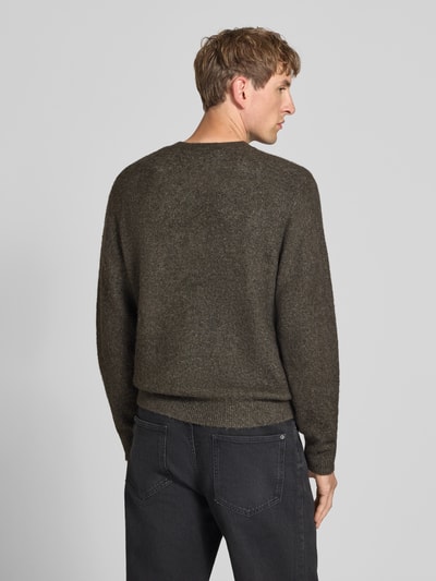 Männermodel trägt Strickpullover mit Logo-Stitching Modell 'CURTIS' von Carhartt Work In Progress in Dunkelgrau, lockerer Schnitt, gerippte Abschlüsse, Material-Mix, Ganzkörperansicht Rückansicht.