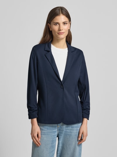 Frauenmodel trägt Blazer mit Raffungen Modell 'Siham' von Soyaconcept in Dunkelblau, Elastischer-Material-Mix, Tailliert, Reverskragen, Knopfverschluss, Rückenlänge 58 cm, Brustweite 50 cm, Ärmellänge 54 cm, Ganzkörperansicht von vorne.