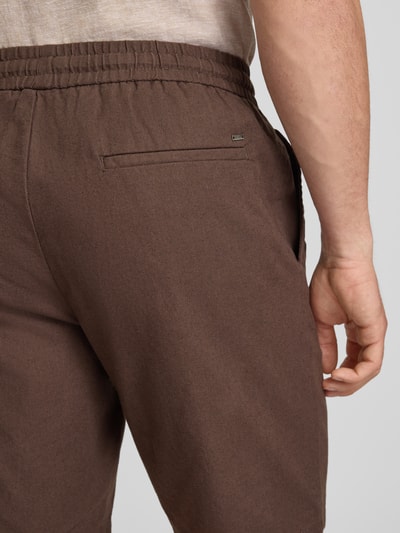 Männermodel trägt Regular Fit Bermudas aus Baumwoll-Leinen-Mix Modell 'LINUS' von Only & Sons, Optik: Unifarben, Detailaufnahme Rückansicht.