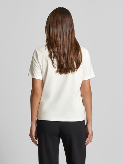 Modelka kobieca ma na sobie T-Shirt mit Motiv-Print od Marc Cain z czystej bawełny, krój regular fit, perły, dekolt okrągły, długość tyłu w rozmiarze 36: 60 cm, biała i czarna kolorystyka, tekstura gładka, widok całej sylwetki z tyłu.