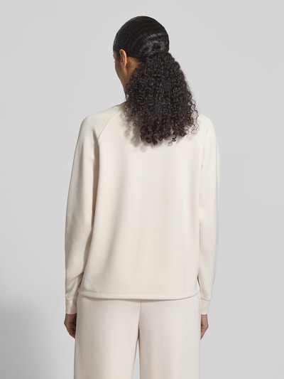 Modelka kobieca nosi Relaxed Fit Sweatshirt mit Stretch-Anteil od Christian Berg Woman, jasny kolor, dzianina z domieszką modalu, krój relaxed fit, dekolt V, długi rękaw, widok całej sylwetki od tyłu.