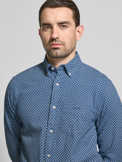 Männermodel trägt Regular Fit Freizeithemd aus Leinen-Baumwoll-Mix von Gant, blauer Allover-Look, Button-Down-Kragen, Nahaufnahme Oberkörper. Rückenlänge bei Größe M: 76 cm, Schulterbreite 47 cm, Ärmellänge 64 cm.