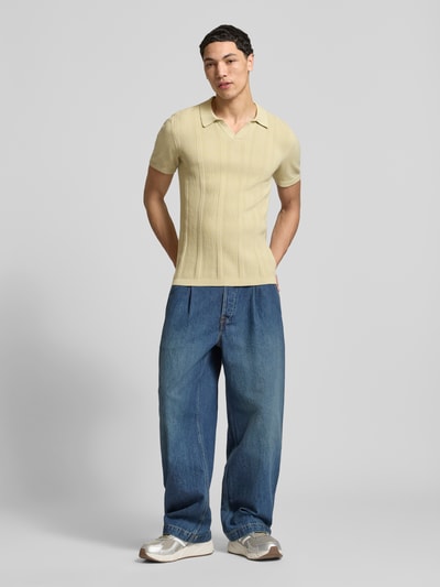 Männermodel trägt Slim Fit Poloshirt in Strick-Optik Modell 'Baron' von Blend, beige, Baumwolle, Polokragen, Ganzkörperansicht von vorne.