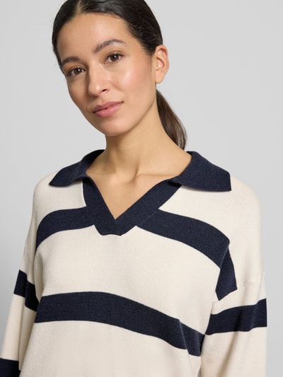 Frauenmodel trägt Strickpullover mit V-Ausschnitt Modell 'KANITA' von Soyaconcept, creme mit dunkelblauen Streifen, Nahaufnahme Oberkörper, Viskose-Mix und gerippte Abschlüsse sind sichtbar.