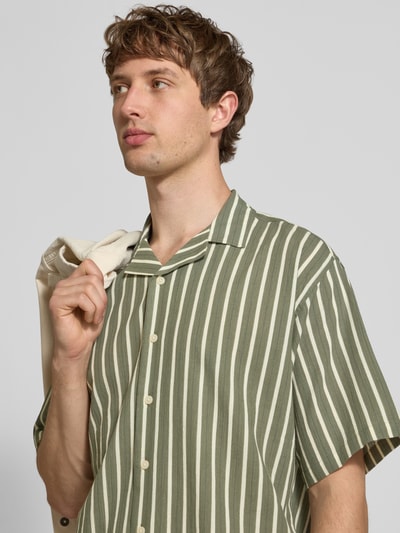 Männermodel trägt Regular Fit Freizeithemd von Redefined Rebel, Modell 'HOWIE', Reine Baumwolle, Allover-Look, Reverskragen, Label-Detail, Nahaufnahme Oberkörper.