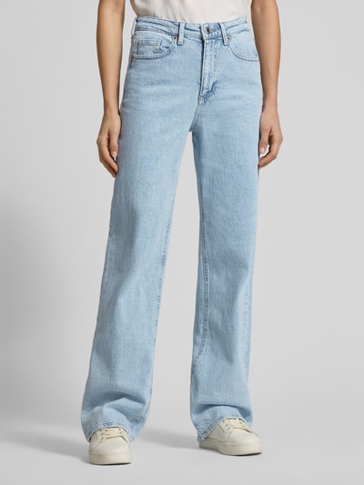 Frauenmodel trägt Wide Leg Jeans aus Baumwoll-Mix Modell 'TESSA' von Vero Moda in hellblauem Denim, Optik: Unifarben, Passform: Wide Leg, High-Waist-Stil, Label Patch, Label-Stitching, Label-Prägung, Gürtelschlaufen, Knopf und verdeckter Reißverschluss, 5-Pocket-Design, Materialverarbeitung: Denim, Ganzkörperansicht von vorne.