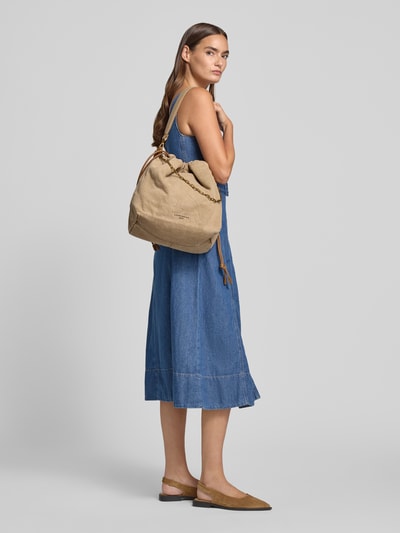 Vrouwenmodel draagt blauwe denim jurk en beige Handtasche mit Logo-Detail Modell 'Lya' van LIEBESKIND BERLIN, hoofdvak met tunnelkoord, afneembare schouderband, breedte 45 cm, lengte 34 cm, diepte 17 cm, bandlengte 119 cm, logodetail, zijaanzicht heuphoogte.