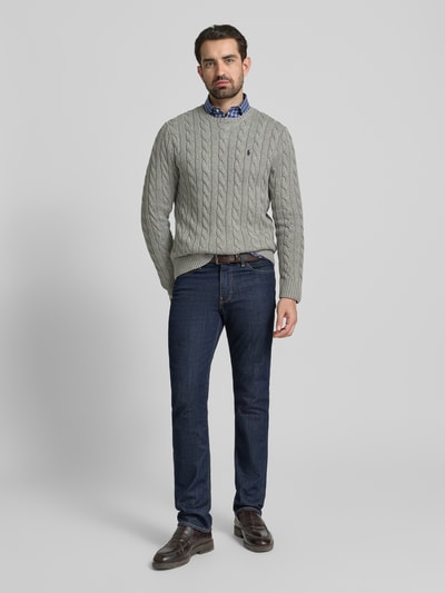 Męski model nosi Strickpullover mit Label-Stitching od Polo Ralph Lauren, szary melanż, czysta bawełna, krój regular fit, ściągacze, okrągły dekolt, z przodu widok całej sylwetki.