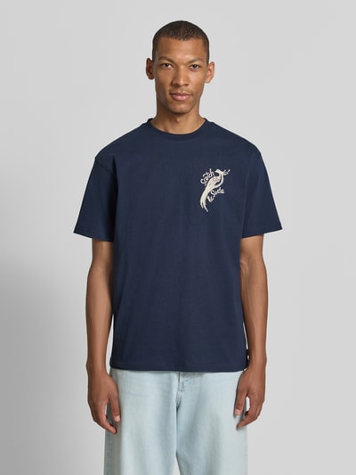 Männermodel trägt Oversized T-Shirt mit Logo-Stitching von Scotch & Soda, reine Baumwolle, Rundhalsausschnitt, Dunkelblau, Ganzkörperansicht von vorne.